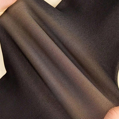 Close-up of brown fabric with a subtle pattern held by hands.